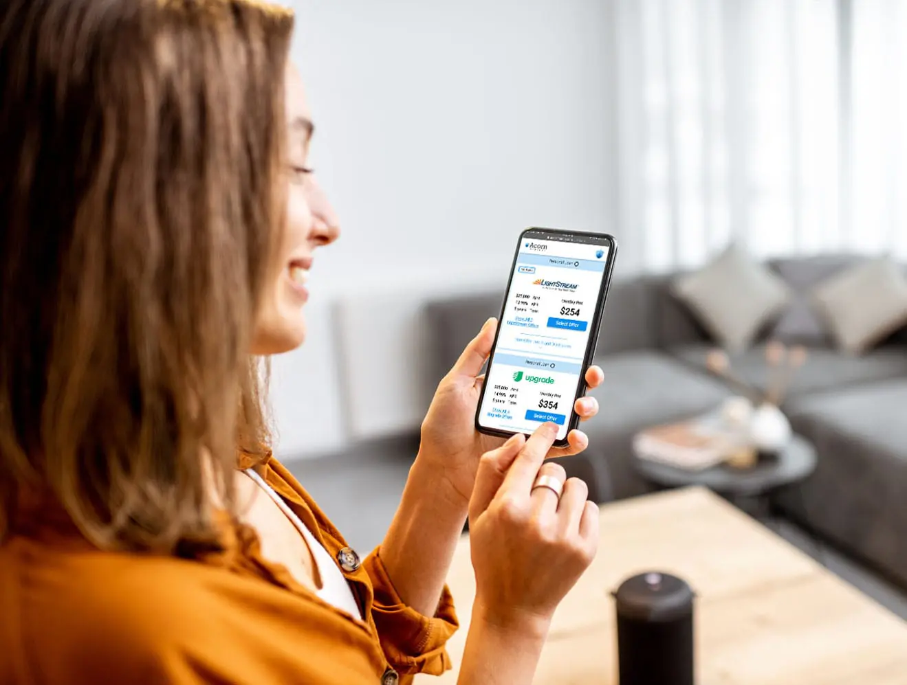 Smiling woman looking at financial information on smartphone.
Smiling woman looking at financial information on smartphone.