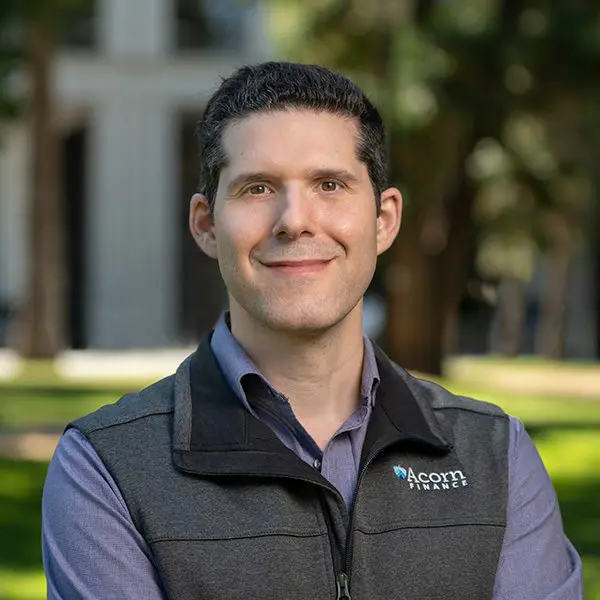 Smiling man's professional headshot in collared shirt and vest. Smiling man's professional headshot in collared shirt and vest.