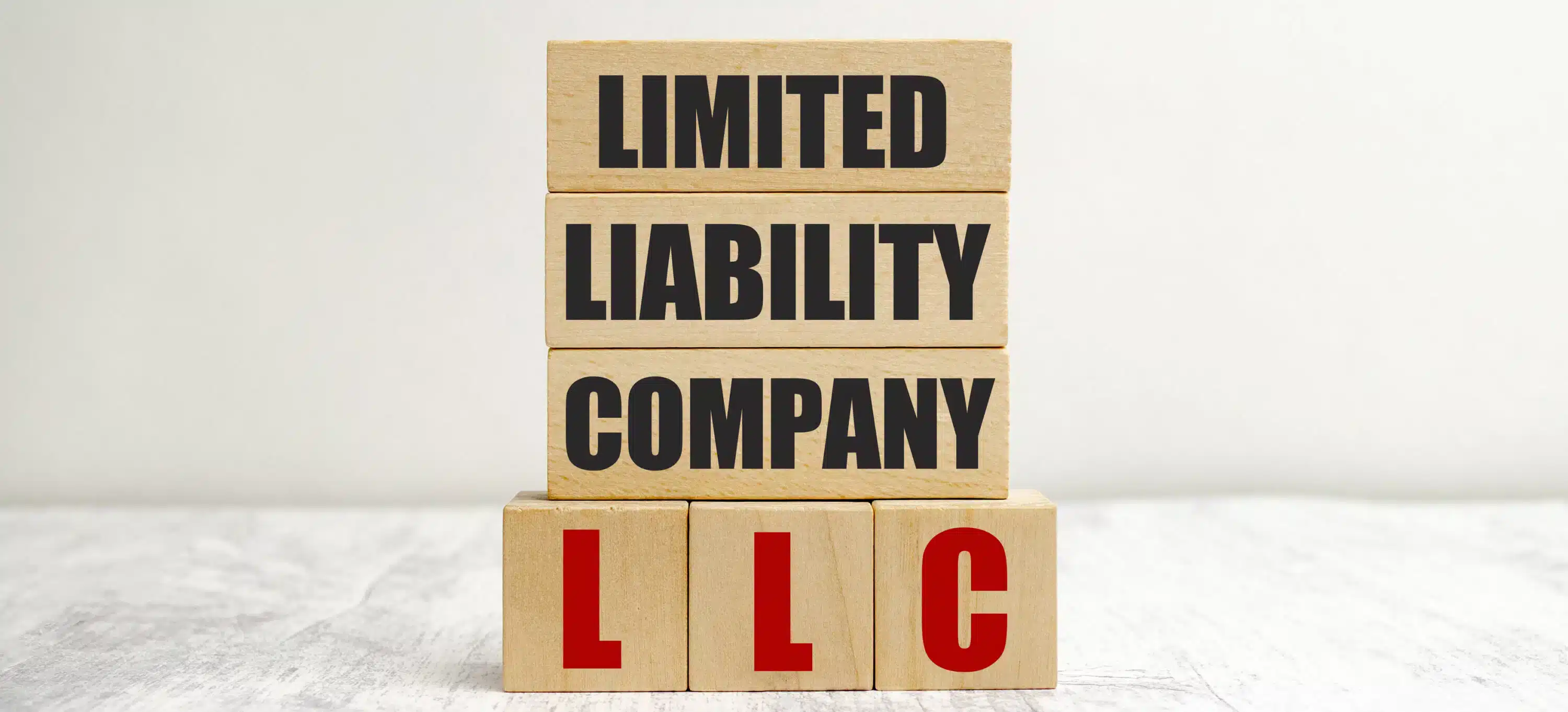 Wooden blocks spell 'limited liability company LLC' representing business loans."